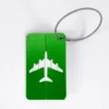 Étiquette à bagages en métal aluminium vert avec motif d'avion découpé et câble en acier. - Vert