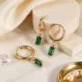Detailaufnahme eleganter rechteckiger grüner Zirkon Anhänger Creolen aus goldenem Titanstahl. - Grün