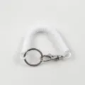 Gros plan détaillé du porte-clés à ressort blanc avec anneau métallique et mousqueton. - Blanc