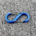 Blauer S-förmiger Karabiner Detail mit doppelten Federklappen und glatter Metalloberfläche. - Blau