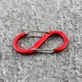 Gros plan détail de mousqueton en S rouge, double crochet à ressort sur fond gris texturé - Rouge