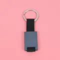 Metallschlüsselanhänger Detailansicht mit schwarzem Schild, Stoffband und Silberring. - Gunmetal