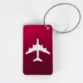 Red aluminum metal luggage tag with hollow airplane silhouette and steel cable ring for travel. - Rose Red