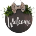 Round wooden welcome hanging sign with burlap bow and artificial green leaves for door decor. - Regular Welcome Style (MPH6001)