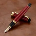 Stylo plume élégant avec corps rayé rouge, garniture dorée et fine plume en métal. - Rouge Cerise