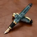 Stylo plume de luxe effet marbré avec attributs dorés et plume fine pour calligraphie élégante. - Cyan Fantôme