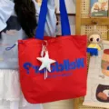 Red canvas tote bag with blue handles and stylish letter print for women daily commute use. - Red