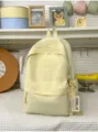 Hellgelber Studenten-Rucksack mit grossem Volumen und stilvollem Fronttaschen-Design ideal. - Mit Anhänger / Gelb