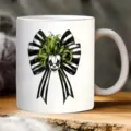Detailed view of a white ceramic coffee mug featuring a spooky black and white striped bow. - Clown Stripe Style