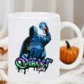 Close-up detail of a white ceramic coffee mug with street graffiti print and orange pumpkin decor. - Street Graffiti