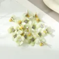Close-up detail of artificial mini silk flower heads for DIY crafts decoration. - Green