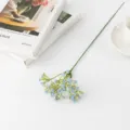 Blue artificial baby breath flower stem close up, plastic flora decor detail for home. - Blue