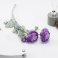 Close-up detail shot of artificial purple ranunculus flower with flocked green stem setup. - Deep purple