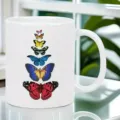 Close-up view of a white ceramic coffee mug featuring a colorful stacked butterfly pattern. - Retro Butterfly Style