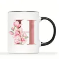 Custom ceramic coffee mug featuring elegant pink floral watercolor magnolia and rose gold letter H. - Letter H