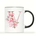 Weißer Keramik Kaffeebecher mit schwarzem Rand Griff und rosa Blumen Buchstabe V Design. - Buchstabe V