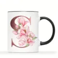 Personalisierte weiße Keramiktasse mit rosa Magnolien und goldenem Buchstaben S Motiv. - Buchstabe S