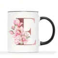 Detailansicht der weißen Keramiktasse mit Roségold Buchstabe E und rosa Magnolienblüten. - Buchstabe E