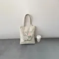 Vista dettagliata della borsa in tela, stile moda casual con design stampato e manici. - Stile 9