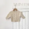 Baby knit cardigan close-up showcasing colorful speckle texture and cute front buttons. - Tops / Apricot with Colorful Dots / 66cm