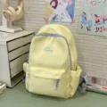 Zaino in tela giallo pastello con cerniere azzurre e tasca frontale, perfetto per la scuola. - Giallo
