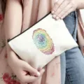 Primo piano di una pochette per cosmetici in tela bianca con stampa di impronta arcobaleno. - Stampa Impronta Digitale Colorata