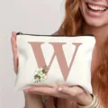 Trousse de maquillage en toile avec lettre W et fleurs, pochette de voyage idéale. - Lettre W