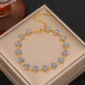 Close-up detail of the luxury blue zirconia four leaf clover gold bracelet design. - Gold Plated Blue Zirconia
