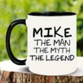Primer plano detallado de una taza de cerámica blanca con asa negra e impresión de texto. - 5