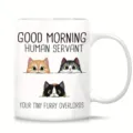 Vista detallada de taza de cerámica blanca con ilustraciones de gatos y texto divertido. - Estilo 3
