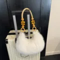 White fluffy plush shoulder bag with stylish wooden bead handle for winter daily fashion wear. - Off White