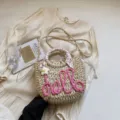 Sac seau en paille tressée fait main avec broderie hello rose, foulard floral et bandoulière chic. - Rose rosé
