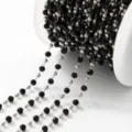 Detailed close-up of a spooling black crystal beaded chain for DIY jewelry making supplies. - 1m / Steel Beads and Black Beads 3mm