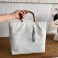 Nischen-Design lässige Segeltuch-Tragetasche mit Bambusgriff und grauem Quastenanhänger. - Mit Anhänger / Weiß