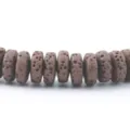 Dettaglio di perline distanziatrici in pietra lavica marrone, ideali per bracciali collane fai da te. - Caffè