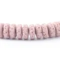 Primo piano di perline distanziatrici in pietra lavica porosa rosa con texture naturali. - Rosa Chiaro