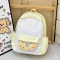 Lindo mochila escolar de lona amarilla con bolsillo delantero transparente y dijes de peluche. - Amarillo