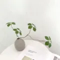 Detailed view of artificial plant vine branch and grey vase for home decor aesthetics. - 11#