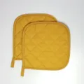 Primo piano della sottopentola trapuntata gialla, accessorio da cucina resistente con passante. - Confezione da 2 / Giallo ocra