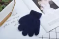 Nahaufnahme der Textur und des Stoffes von dunkelblauen Strick-Fünffinger-Winterhandschuhen. - Alter 2-6 Einheitsgröße / Marineblau