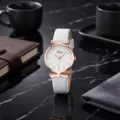 Primer plano de reloj de cuarzo para mujer con correa de piel sintética blanca y caja. - Blanco