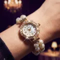 Vista detallada reloj cuarzo mujer con estrás bisel flor y pulsera elástica perlas. - Escala de Strass Romano Floral / Dorado