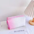 Pink and white gradient cosmetic bag detail, featuring stylish chevron quilting and zip. - Pink