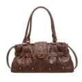 Bolso de hombro retro marrón de cuero sintético con hebillas metálicas y remaches detallados. - Marrón