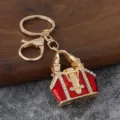 Vue détaillée de l'exquis porte-clés sac à main miniature émaillé rouge et des strass brillants. - Rouge