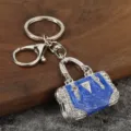 Silver metal keychain with blue enamel handbag pendant and sparkling rhinestones. - White K + Blue