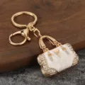 Metal rhinestone handbag keychain detail, luxury gold keyring bag charm pendant accessory. - KC Gold + White