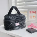 Black shiny quilted cosmetic bag with padded handle, stylish travel toiletry organizer for daily use. - Large Cosmetic Bag / Black
