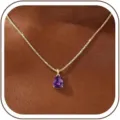 Vista detallada del elegante colgante con gema morada en forma de gota y excelente acabado. - 14k / Febrero - Dorado