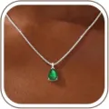 Close-up view of a pear-shaped green zircon pendant on a silver box chain necklace. - 14k / May-Silver